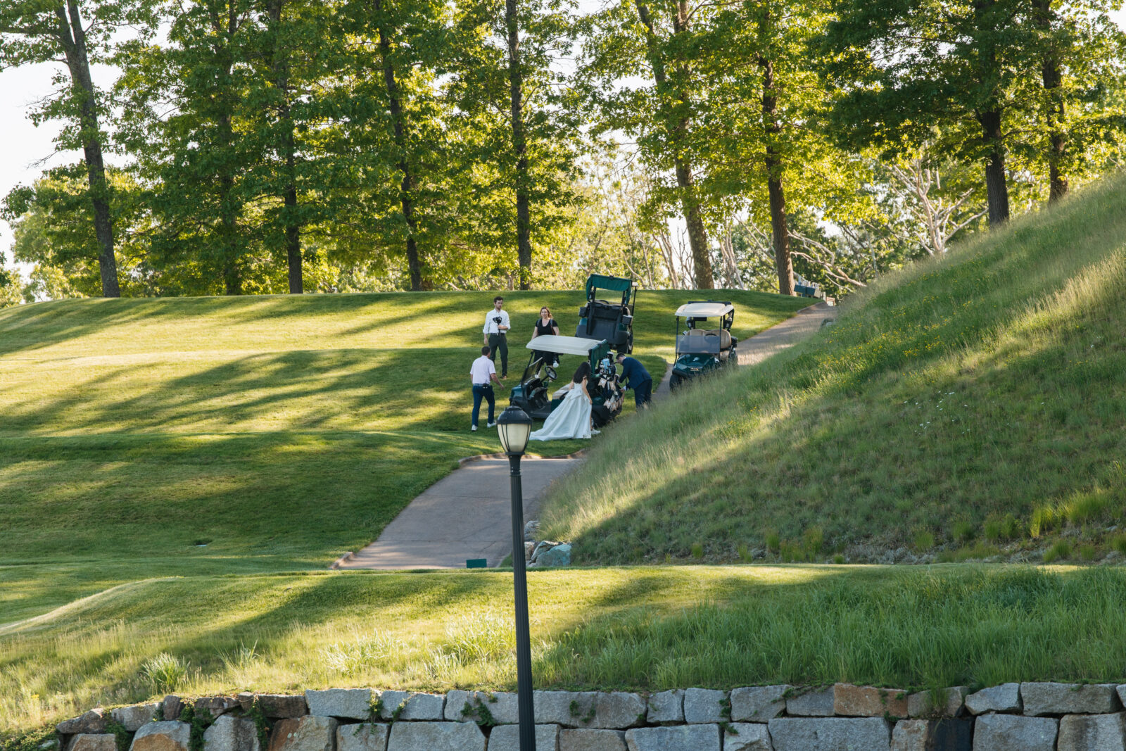 
A special moment as Alix and Wiley tee off together at the 10th hole of Turner Hill, just after their ceremony. Surrounded by family and friends watching from the ceremony site, this unique moment reflects their love for the club and adds a personal touch to their wedding day.