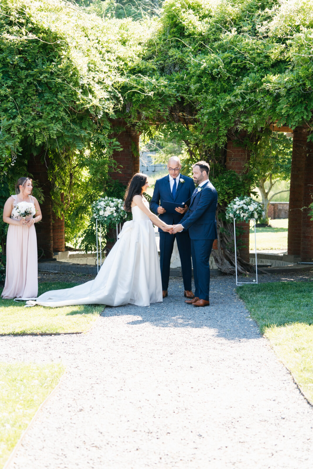 
A beautiful and emotional moment during Alix and Wiley’s outdoor ceremony at Turner Hill, as they exchange vows surrounded by lush greenery and their loved ones. The love and joy shared between the couple is evident, making this a truly unforgettable moment in their celebration.