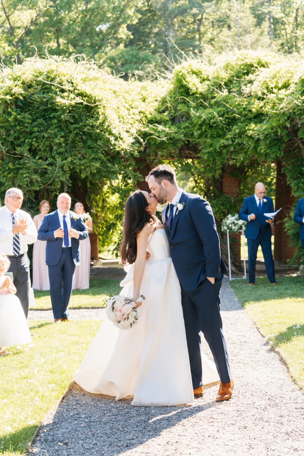 
A beautiful and emotional moment during Alix and Wiley’s outdoor ceremony at Turner Hill, as they exchange vows surrounded by lush greenery and their loved ones. The love and joy shared between the couple is evident, making this a truly unforgettable moment in their celebration.