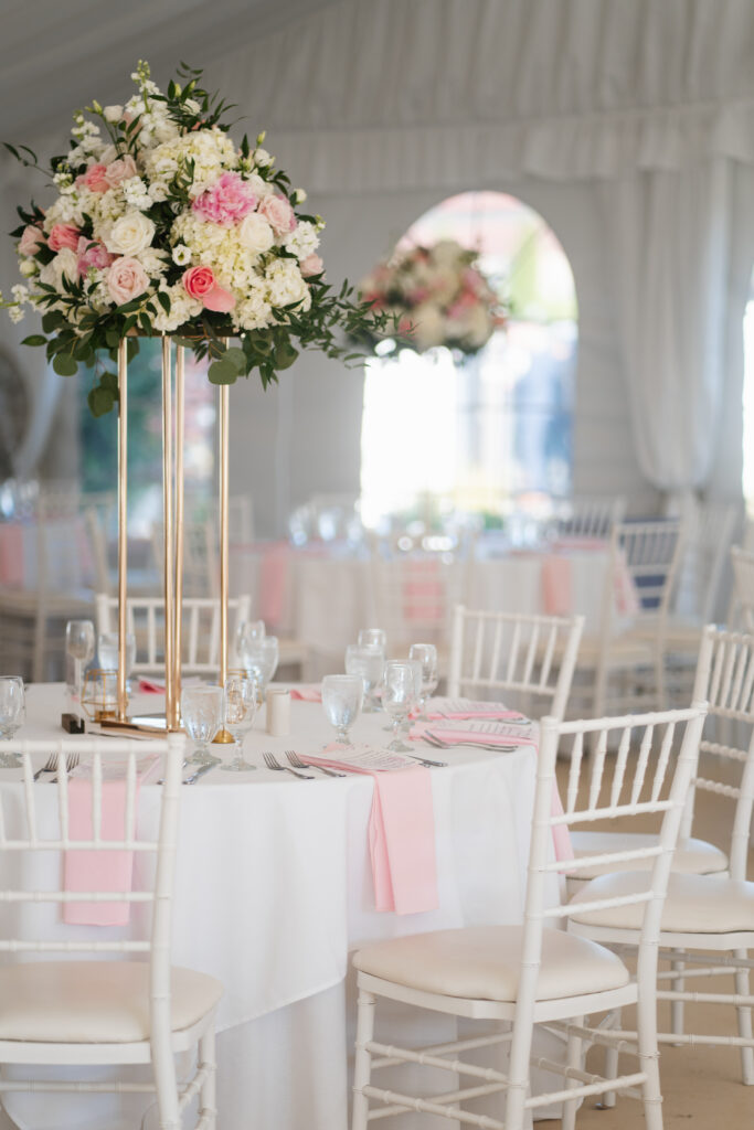 A stunning image of a wedding ceremony at The Villa in Bridgewater, capturing the elegant outdoor setting with manicured gardens and a charming gazebo. The soft, natural light creates a romantic ambiance as the couple exchanges vows, with guests seated on the beautifully arranged lawn. The venue’s classic architecture and picturesque surroundings make it a truly enchanting backdrop for a memorable day.