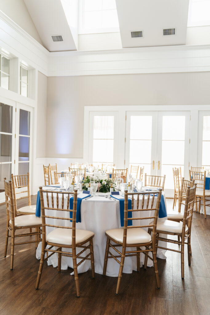 A breathtaking shot of a wedding ceremony at Waverly Oaks in Plymouth, featuring the lush greenery of the venue’s expansive grounds. The couple stands under a beautifully adorned arch, surrounded by tall trees and soft sunlight filtering through, creating a romantic and serene atmosphere. The picturesque backdrop highlights the natural beauty of the venue, making it the perfect setting for a memorable celebration.