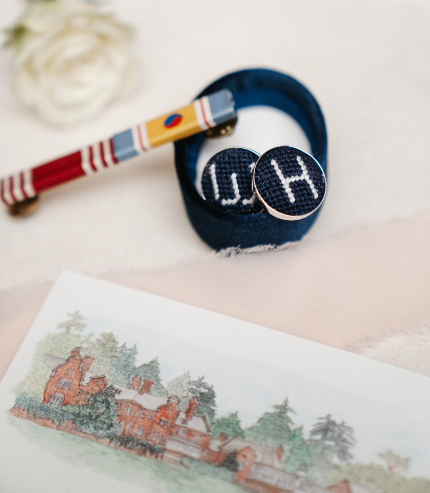 A close-up shot showcasing the stunning wedding details, including custom cufflinks, delicate floral arrangements, and the elegant invitations, all thoughtfully planned to reflect the couple’s personal style and love for one another.