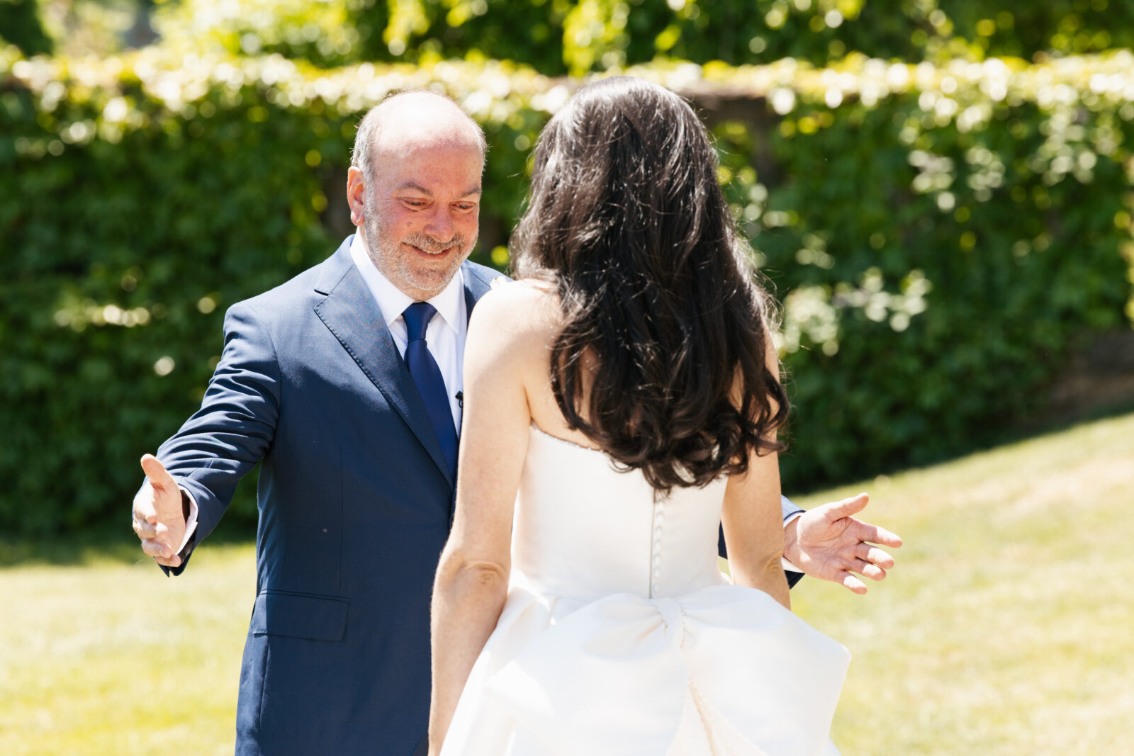 A heartfelt moment as Alix shares a first look with her dad, filled with emotion and love. His face lights up with pride and joy as he sees his daughter in her stunning wedding gown for the first time.