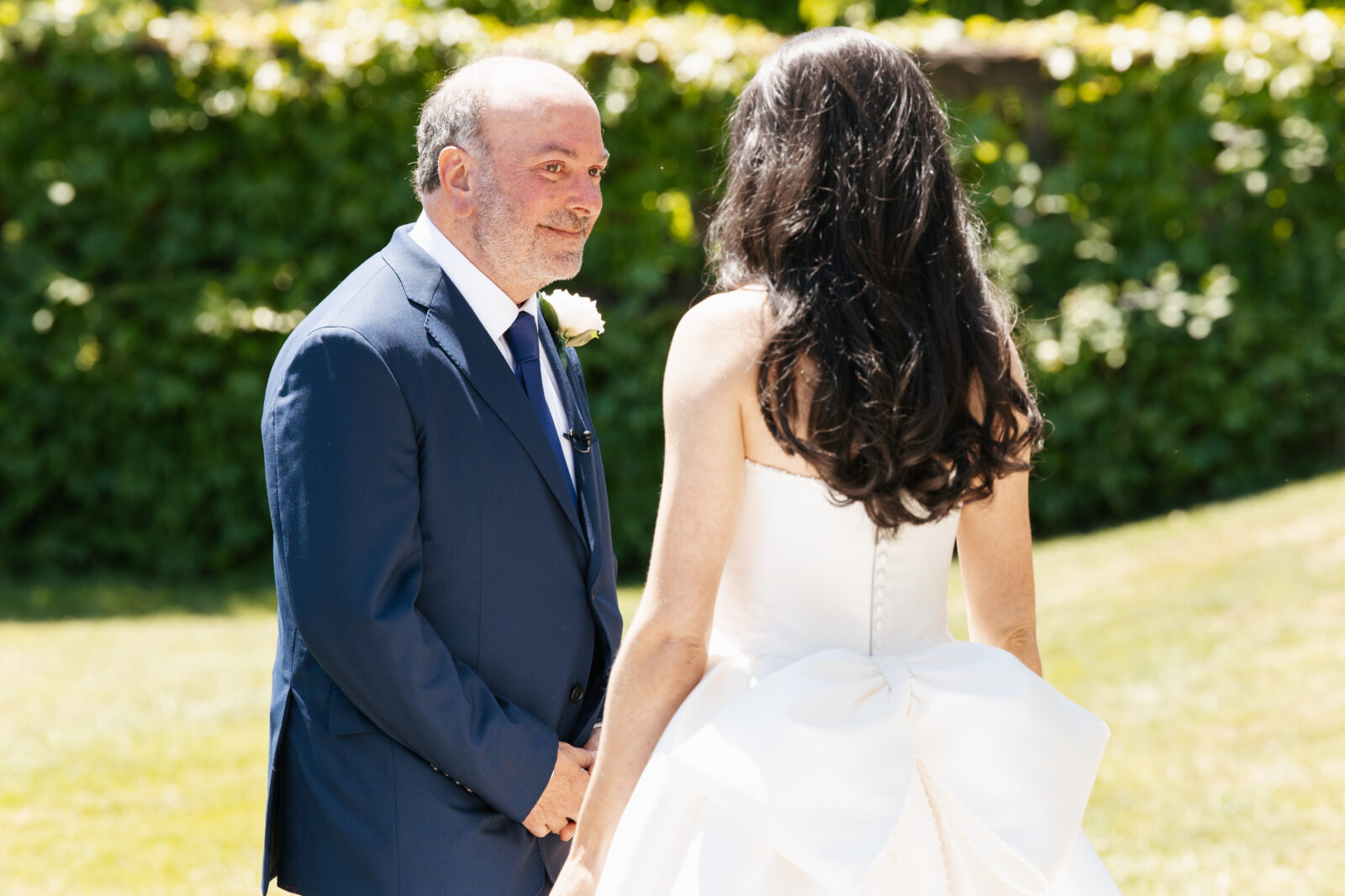 A heartfelt moment as Alix shares a first look with her dad, filled with emotion and love. His face lights up with pride and joy as he sees his daughter in her stunning wedding gown for the first time.