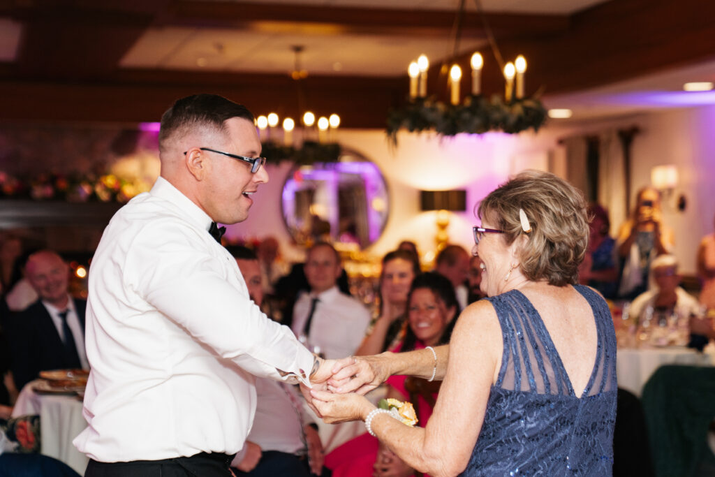 
A vibrant, candid photo of a wedding couple sharing a joyful moment during their celebration, with soft, natural lighting highlighting the colors and emotions of the day. The image captures an authentic, in-between moment that showcases the couple’s connection and the love in the air.