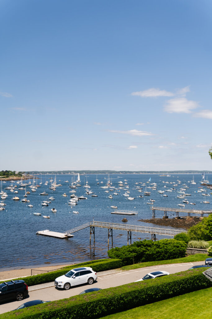 
A breathtaking image of a wedding at Eastern Yacht Club in Marblehead, featuring the couple on the dock with the stunning harbor and sailboats in the background. The soft, golden light reflects off the water, creating a romantic and tranquil atmosphere. The venue’s elegant nautical setting and coastal views make for a perfect blend of sophistication and natural beauty, setting the stage for a memorable waterfront celebration.