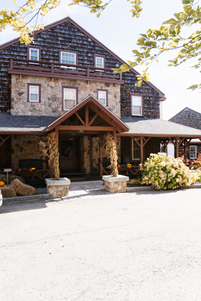 A picturesque photo of a wedding ceremony at Steele Hill Resort in Sanborton, with the couple exchanging vows against the breathtaking backdrop of New Hampshire’s lakes and mountains. The expansive views of the rolling hills and sparkling water create a serene and dramatic atmosphere, while the soft, natural light adds a romantic touch. The resort’s stunning outdoor setting provides the perfect combination of nature’s beauty and elegant celebration.