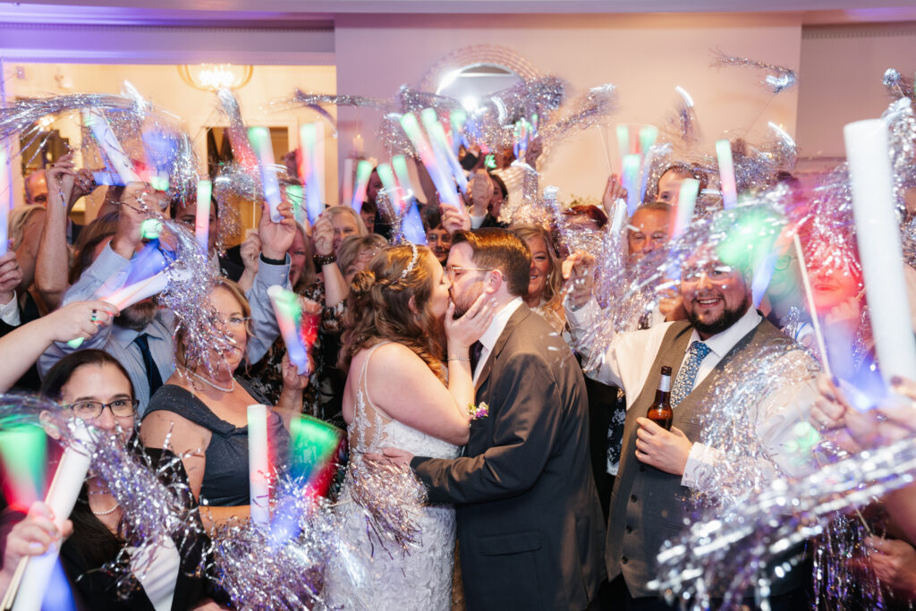 
A vibrant, candid photo of a wedding couple sharing a joyful moment during their celebration, with soft, natural lighting highlighting the colors and emotions of the day. The image captures an authentic, in-between moment that showcases the couple’s connection and the love in the air.