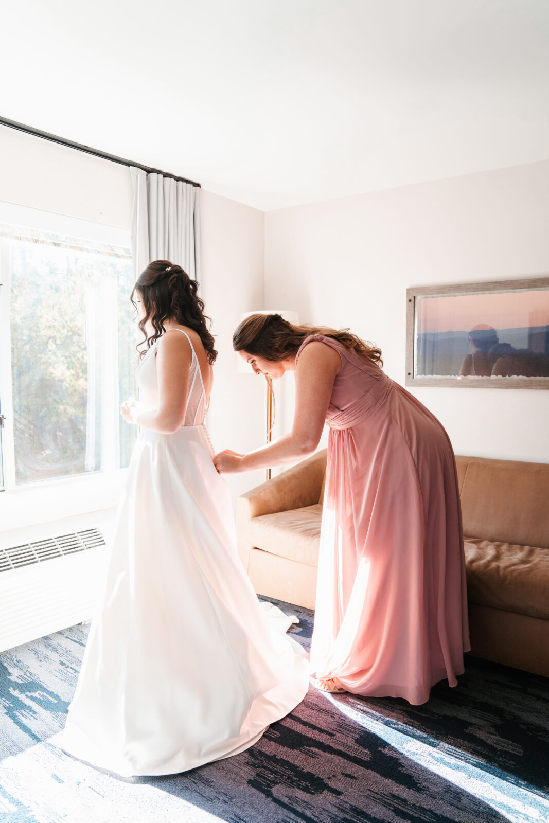 Bride getting ready in the bridal suite at Waverly Oaks in Plymouth, MA, surrounded by natural light and soft, elegant details.
