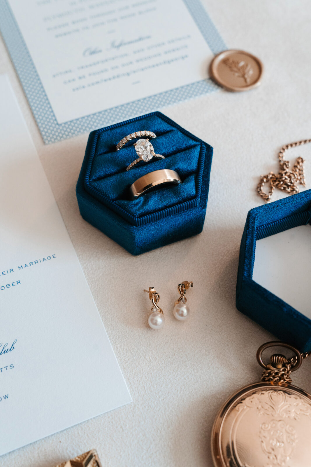 Elegant wedding flat lay with invitation suite, rings, and florals styled on soft linen at Waverly Oaks in Plymouth, MA.