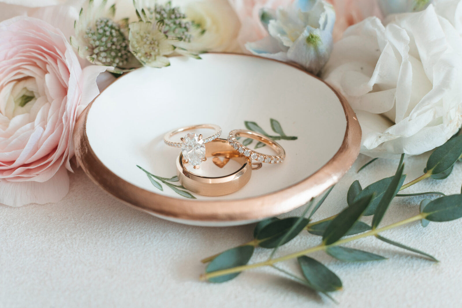 Elegant wedding flat lay with invitation suite, rings, and florals styled on soft linen at Waverly Oaks in Plymouth, MA.