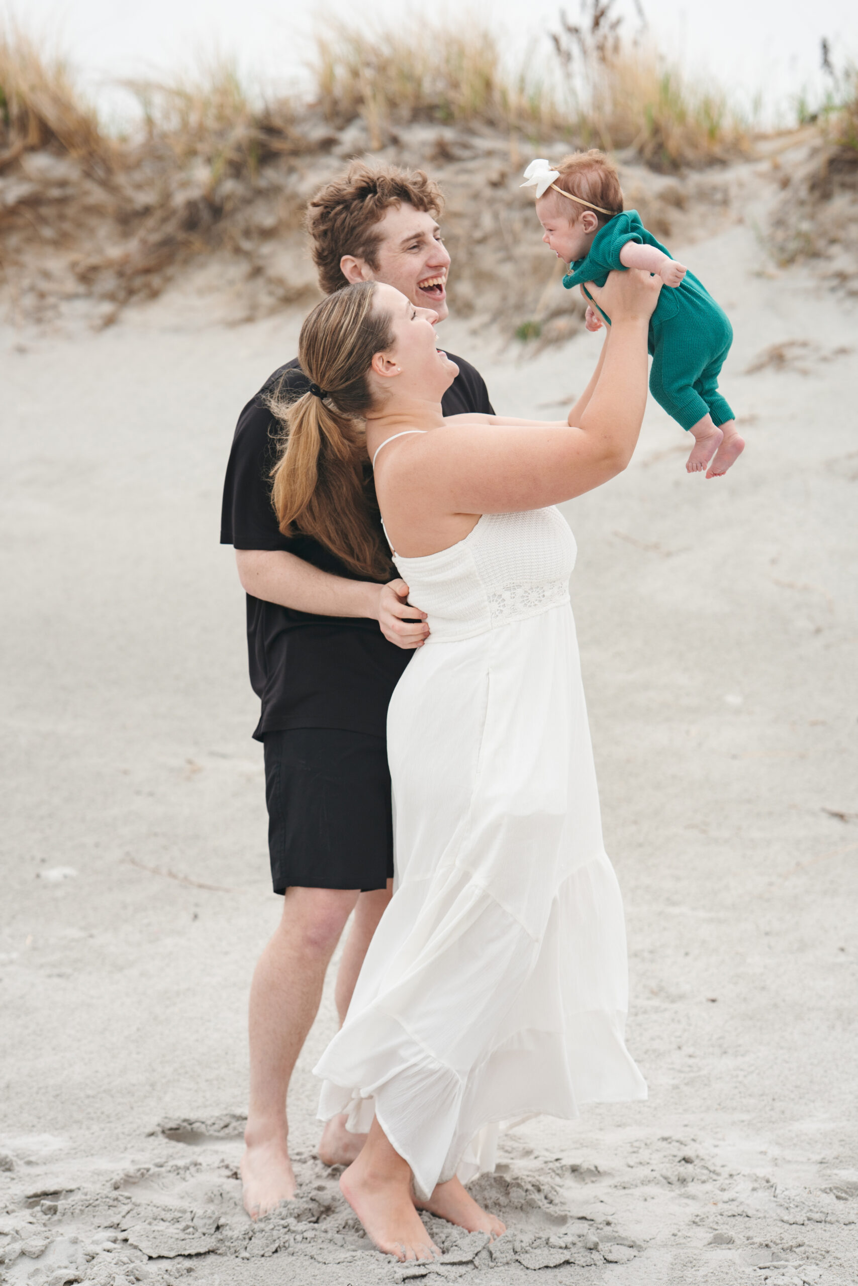 Couple with daughter during engagement photos on the beach