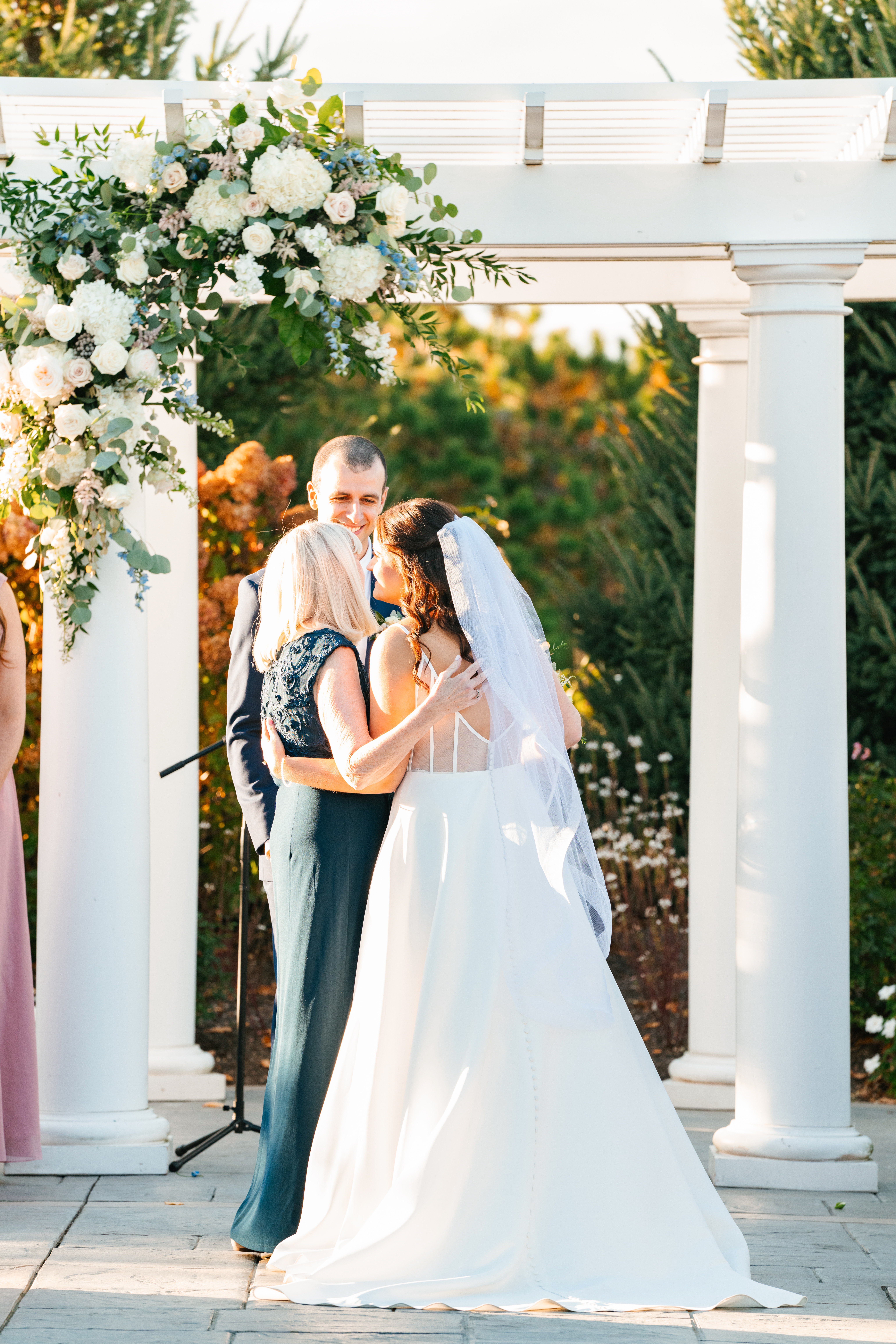 Elegant outdoor wedding ceremony at Waverly Oaks in Plymouth, MA with lush greenery and classic white chairs.