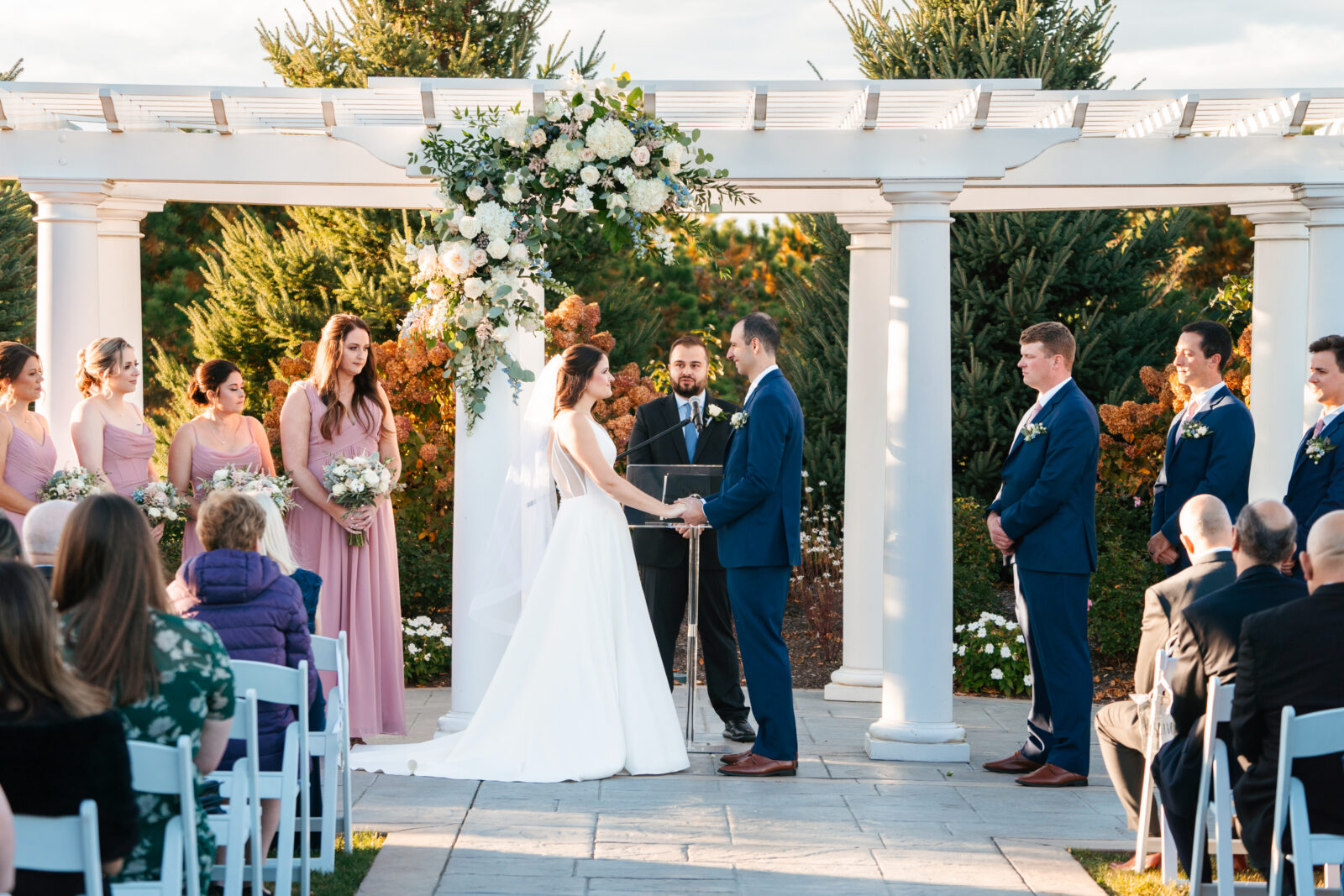 Elegant outdoor wedding ceremony at Waverly Oaks in Plymouth, MA with lush greenery and classic white chairs.