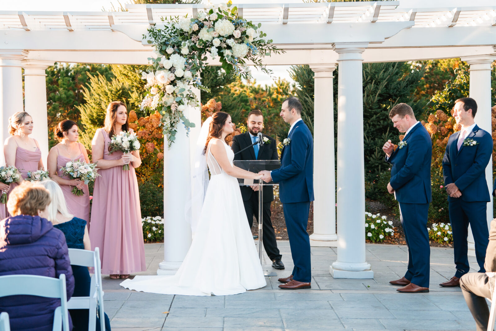 Elegant outdoor wedding ceremony at Waverly Oaks in Plymouth, MA with lush greenery and classic white chairs.