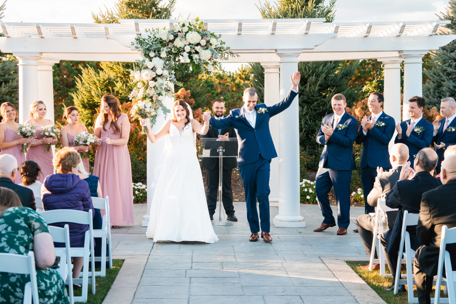 Elegant outdoor wedding ceremony at Waverly Oaks in Plymouth, MA with lush greenery and classic white chairs.