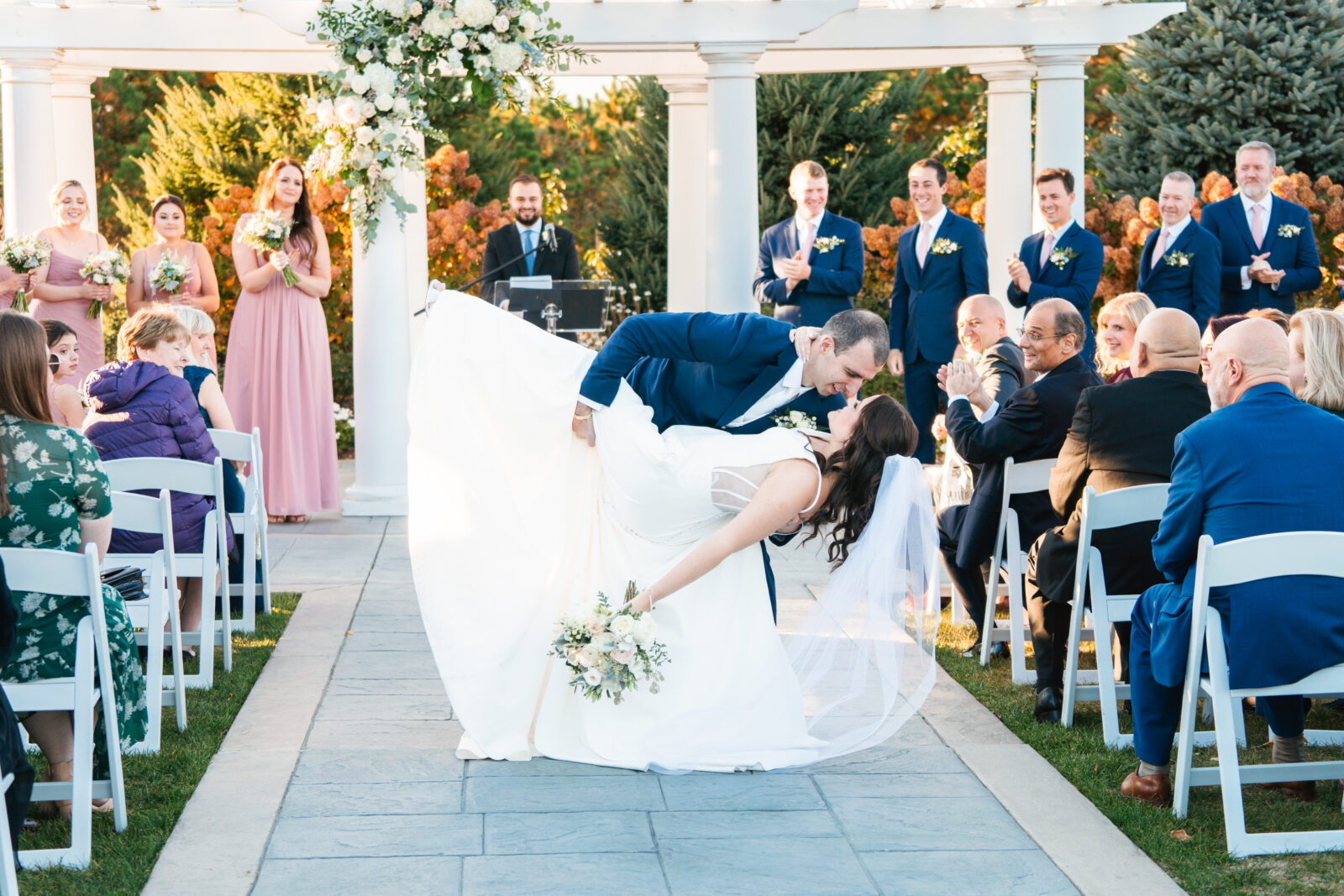 Elegant outdoor wedding ceremony at Waverly Oaks in Plymouth, MA with lush greenery and classic white chairs.