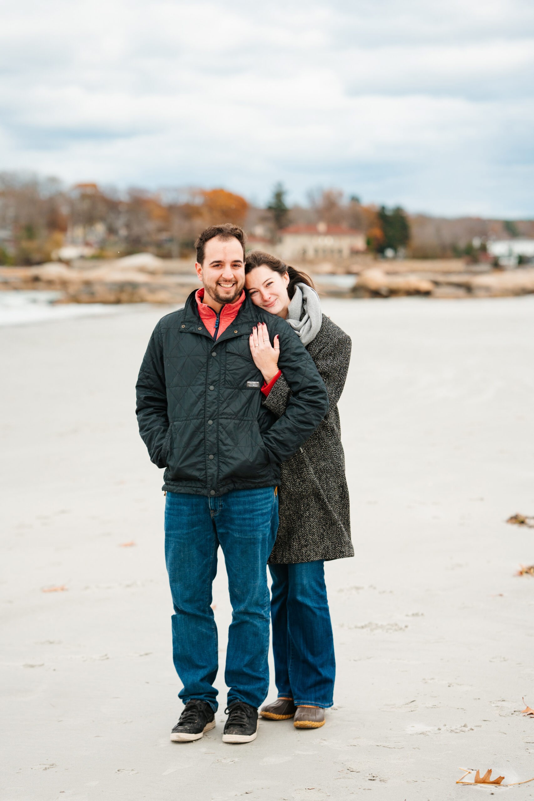 couple taking photos on the beach after getting engaged