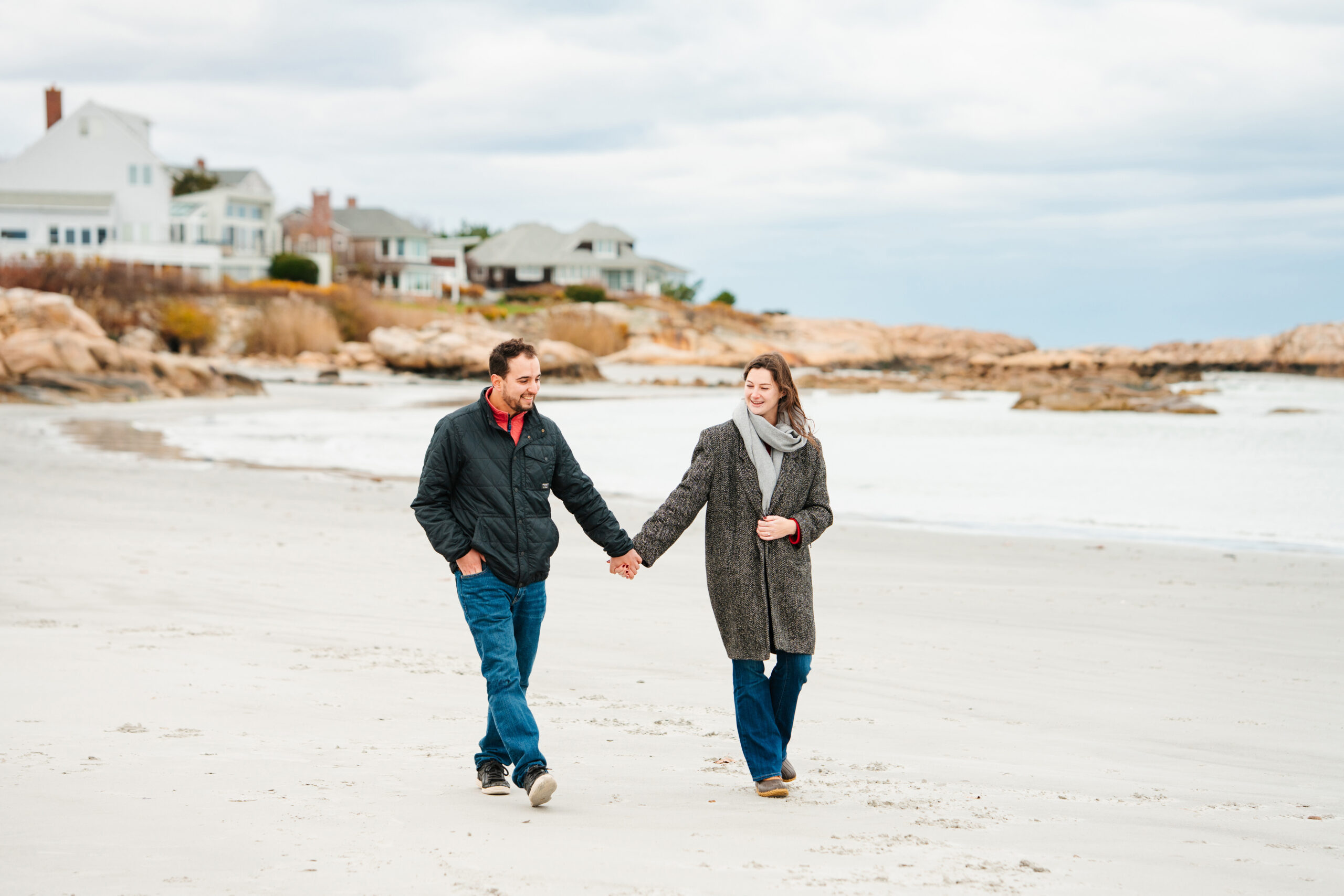 New England engagement photos on the beach, couple walking hand in hand