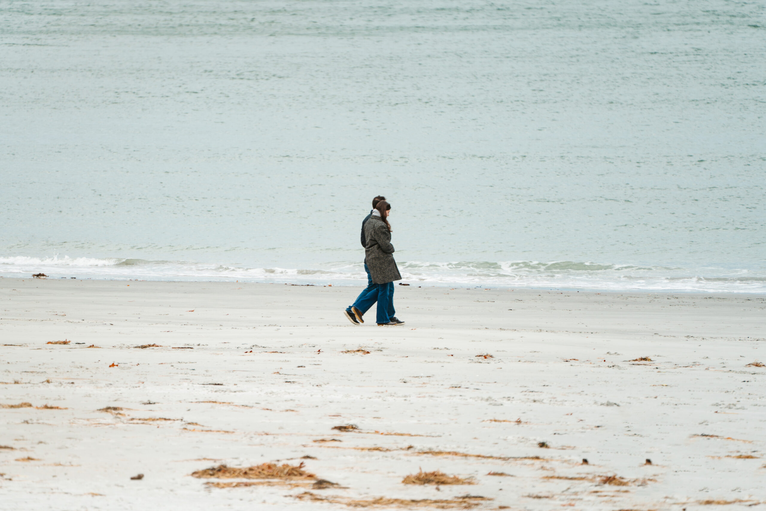 boyfriend and girlfriend walking on the beach moments before getting engaged