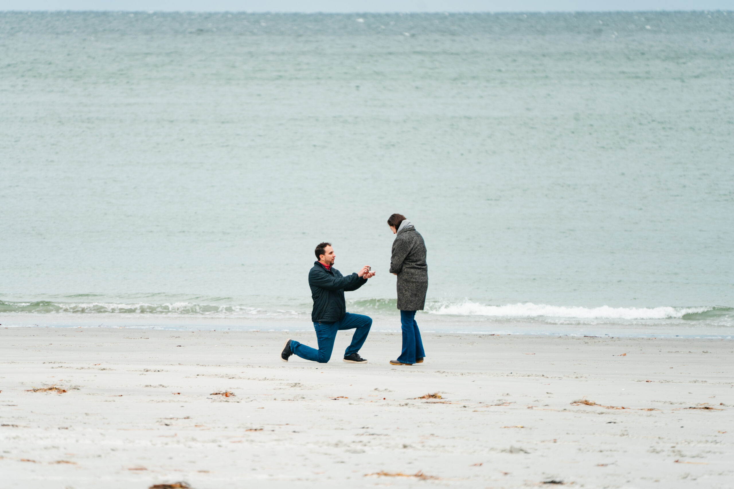 man proposing to his girlfriend on beach in Massachusetts
